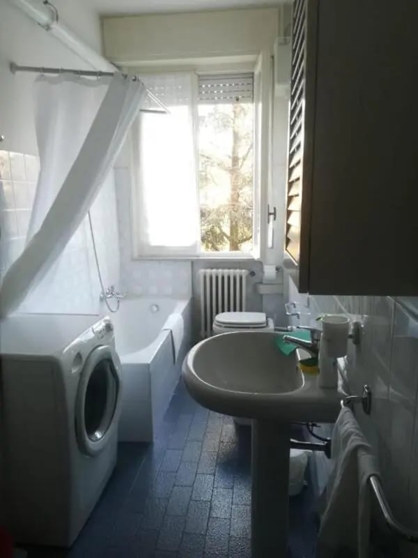 Washer bathtub toilet sink and shower curtain bathroom at Comfy 2 bedroom apartment close to Palazzo Ducale in Parma Student Accommodation