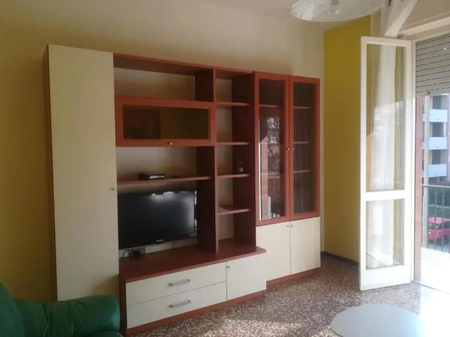 Entertainment unit with TV and glass cabinets living room at Comfy 2 bedroom apartment close to Palazzo Ducale in Parma Student Accommodation
