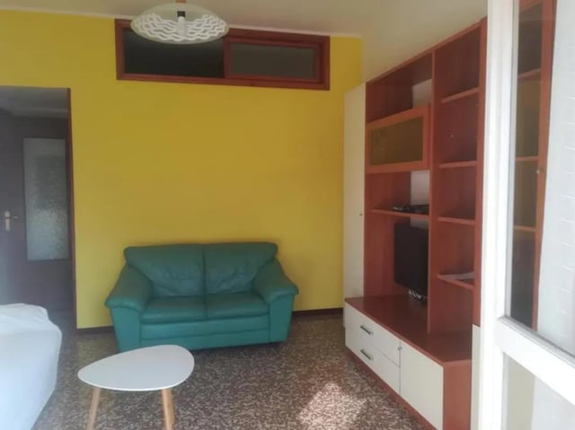 Green sofa tv unit and coffee table living room at Comfy 2 bedroom apartment close to Palazzo Ducale in Parma Student Accommodation