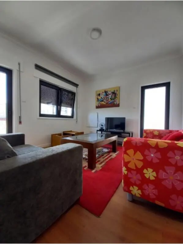 Sofa coffee table television rug red living room at Nice Twin Bedroom close to City Park of Viana do Castelo in Viana Do Castelo Student Accommodation