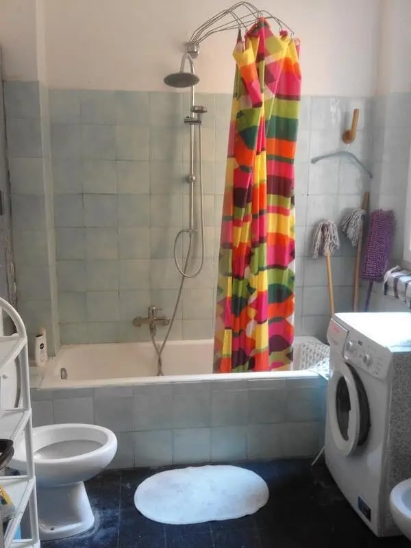Colorful shower curtain toilet tub washing machine bathroom at Single Bedroom in a 4 bedroom apartment in Parma in Parma Student Accommodation