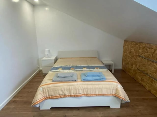 Bed with towels and nightstands bedroom at Welcoming Studio close to Viana do Castelo Center/Train Station in Viana Do Castelo Student Accommodation