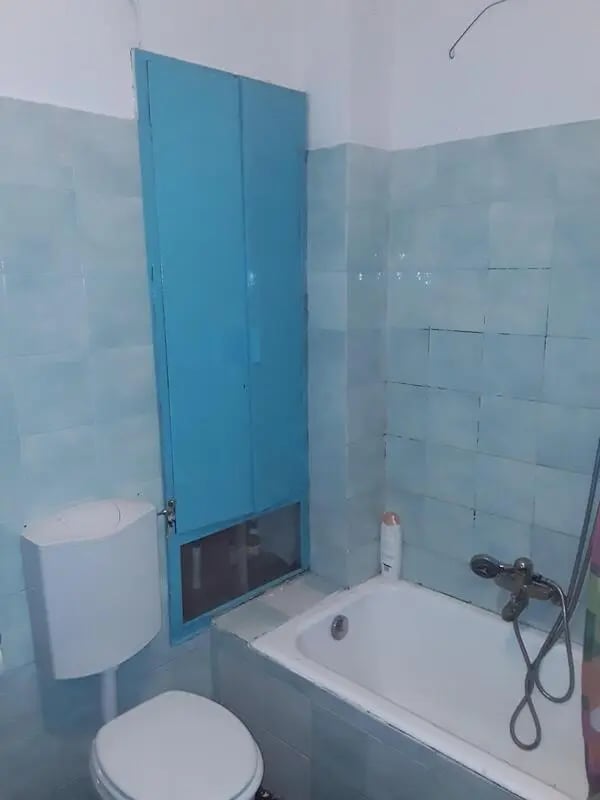 Toilet bathtub blue cabinet bathroom at Single Bedroom in a 4 bedroom apartment in Parma in Parma Student Accommodation