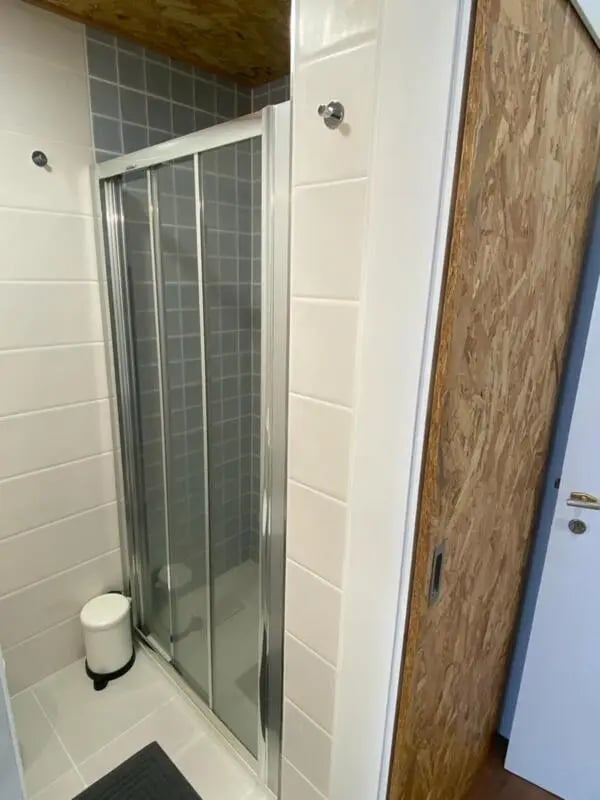 Shower stall white bin sliding door bathroom at Welcoming Studio close to Viana do Castelo Center/Train Station in Viana Do Castelo Student Accommodation