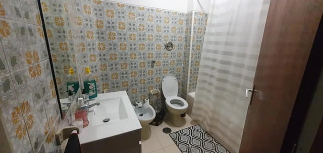 Sink toilet bidet shower curtain patterned tiles bathroom at Double Bedroom close to Minho University 7 in Guimaraes Student Accommodation