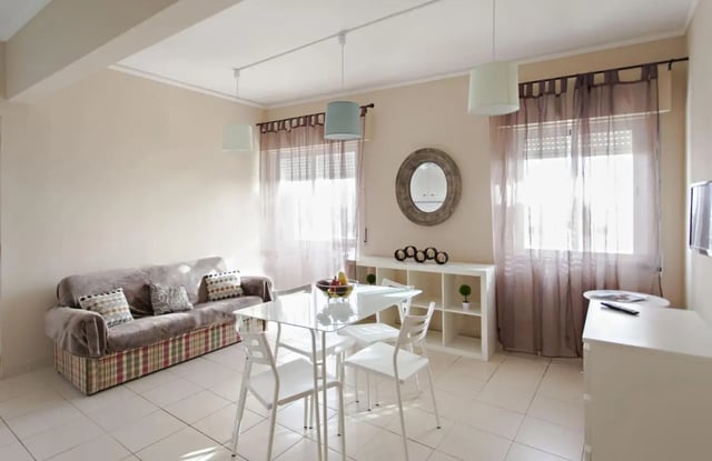 Sofa dining table shelf mirror living room at Sunny and lovely 1-bedroom flat in Faro Student Accommodation