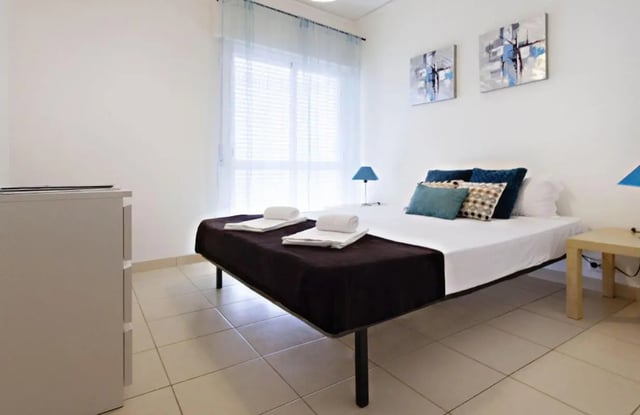 Bed with pillows and artworks bedroom at Sunny and lovely 1-bedroom flat in Faro Student Accommodation