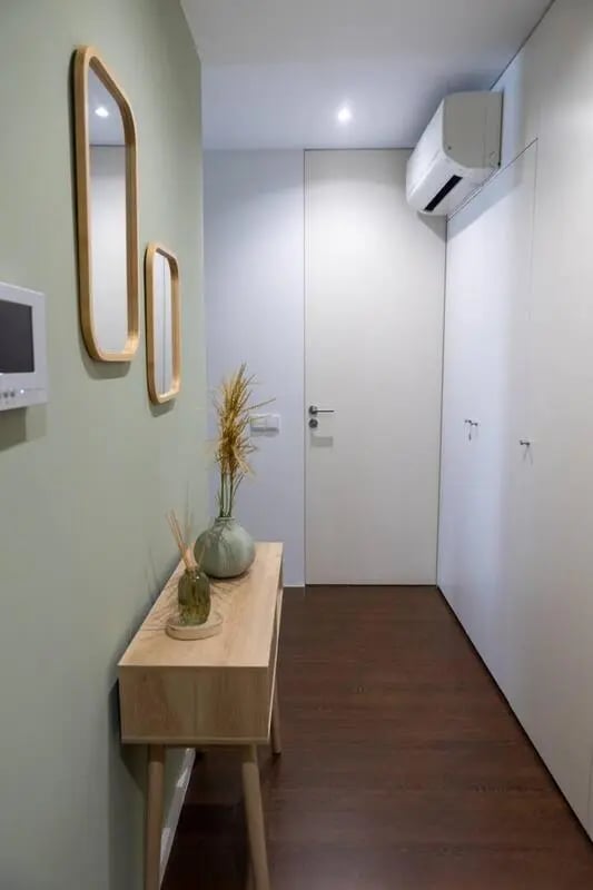 Entryway with console table mirrors and air conditioner entrance at Elegant and functional studio in the historic center of Guimarães in Guimaraes Student Accommodation