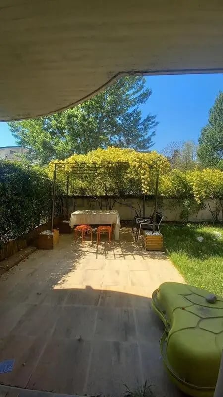 Covered patio table with chairs and greenery exterior at Comfy 3 bedroom apartment close to University of Parma in Parma Student Accommodation