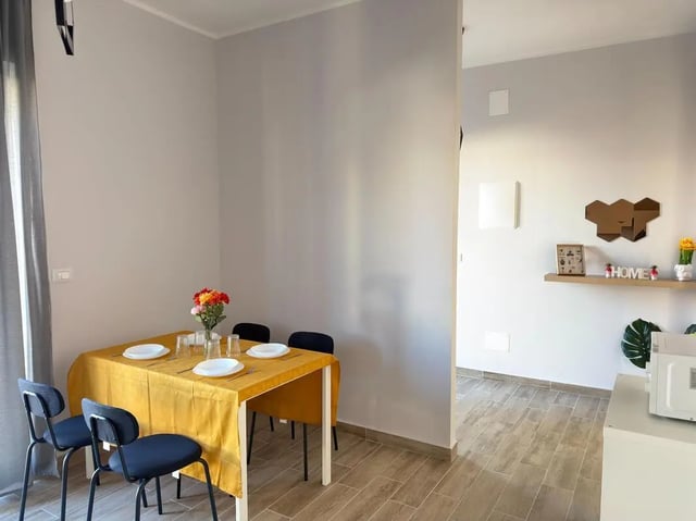 Yellow dining table with chairs and flowers Dining room at Amazing bedroom in Pescara in Pescara Student Accommodation