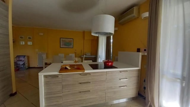 Kitchen island with red pot and wine glass kitchen at Comfy 3 bedroom apartment close to University of Parma in Parma Student Accommodation