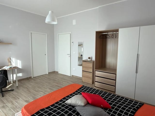 Bed with orange bedding desk closet bedroom at Amazing bedroom in Pescara in Pescara Student Accommodation