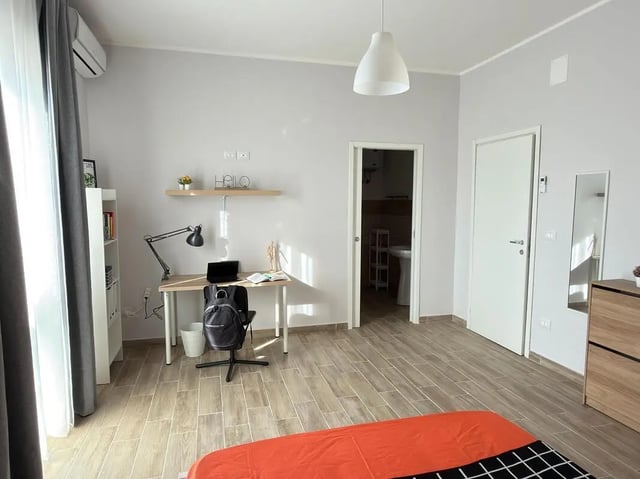 Desk with laptop bookshelf and bed bedroom at Amazing bedroom in Pescara in Pescara Student Accommodation