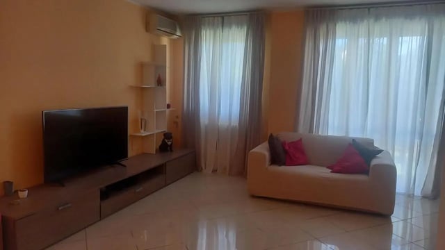 TV couch shelves and large windows living room at Comfy 3 bedroom apartment close to University of Parma in Parma Student Accommodation