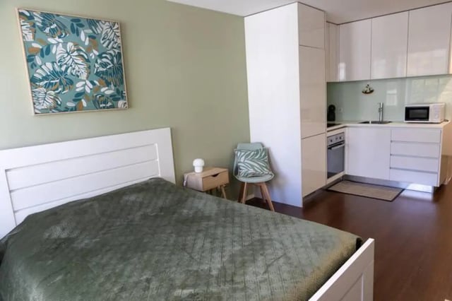 Bed with kitchen area and art studio apartment at Elegant and functional studio in the historic center of Guimarães in Guimaraes Student Accommodation