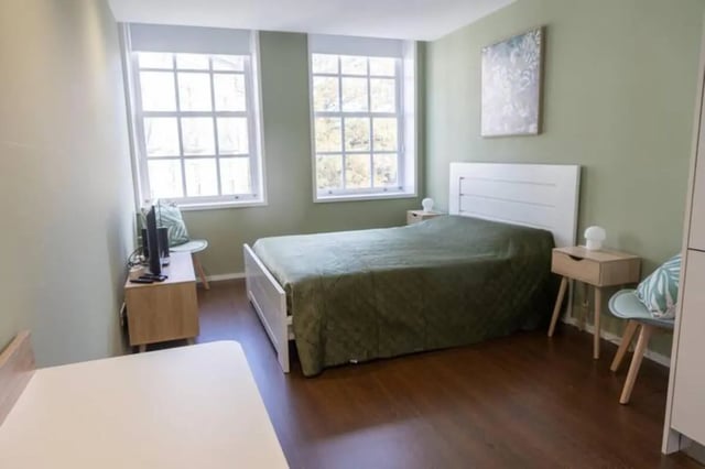 Bed nightstands TV and windows bedroom at Elegant and functional studio in the historic center of Guimarães in Guimaraes Student Accommodation