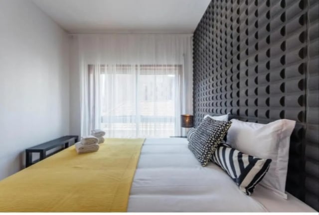 Bed with yellow throw white pillows bedroom at Excellent 3-bedroom apartment next to General Torres metro station in Vila Nova De Gaia Student Accommodation