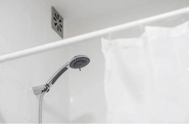 Showerhead chrome shower curtain ventilation grate bathroom at Excellent 3-bedroom apartment next to General Torres metro station in Vila Nova De Gaia Student Accommodation