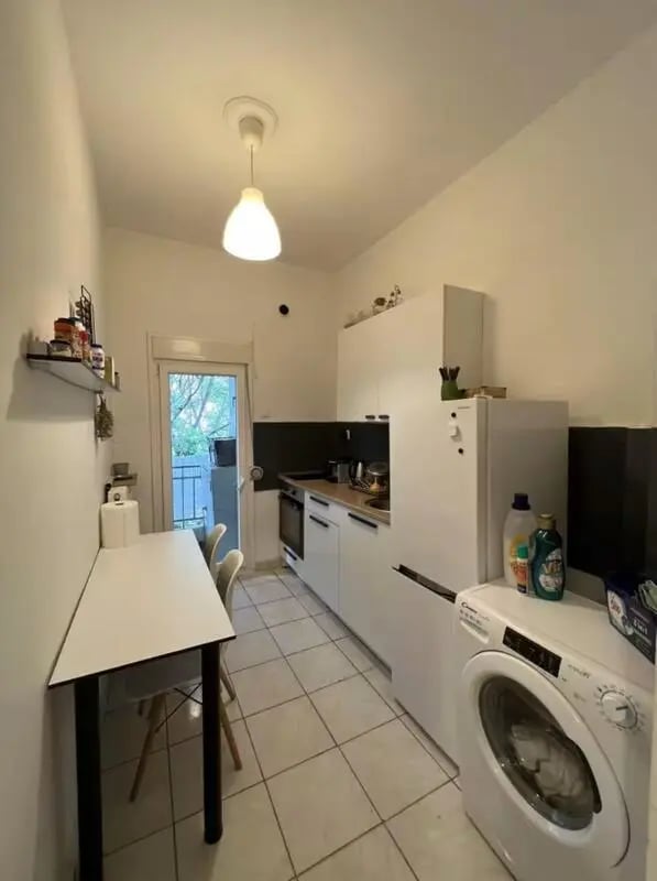 Table chairs counter fridge washing machine kitchen at Homely Double Bedroom with a balcony close to Aristotelous Square in Thessaloniki Student Accommodation