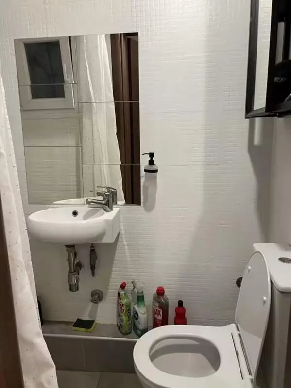 Sink mirror toilet cleaning supplies bathroom at Homely Double Bedroom with a balcony close to Aristotelous Square in Thessaloniki Student Accommodation