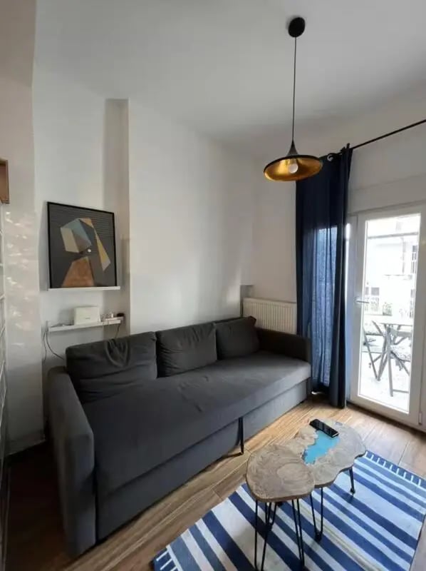 Gray sofa abstract art blue curtains living room at Homely Double Bedroom with a balcony close to Aristotelous Square in Thessaloniki Student Accommodation