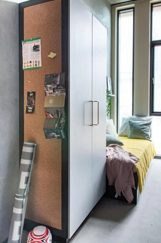 Corkboard bed wardrobe with yellow bedding bedroom at Cool single ensuite bedroom close to Aarhus Universitet in Aarhus Student Accommodation