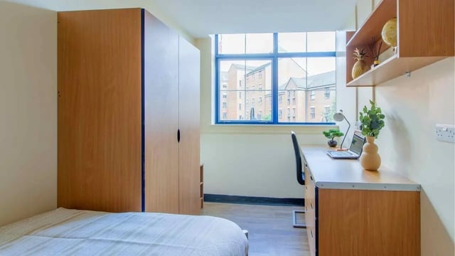 Bed wardrobe desk laptop and chair student bedroom at Ben Russell Court in Leicester Student Accommodation