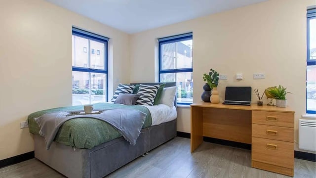 Bed desk with laptop and plant bedroom study area at Ben Russell Court in Leicester Student Accommodation