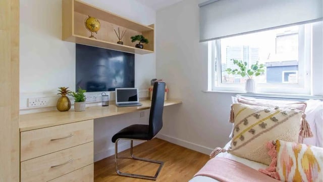 Desk with laptop globe and pineapple bedroom at Canalside in Birmingham Student Accommodation