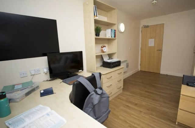 Desk with computer printer books and backpack bedroom at Daisybank Villas in Manchester Student Accommodation
