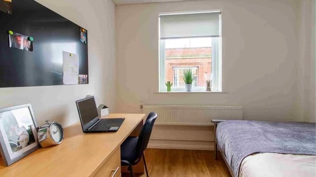 Desk with laptop bed and blackboard bedroom at Danesgate House in Lincoln Student Accommodation