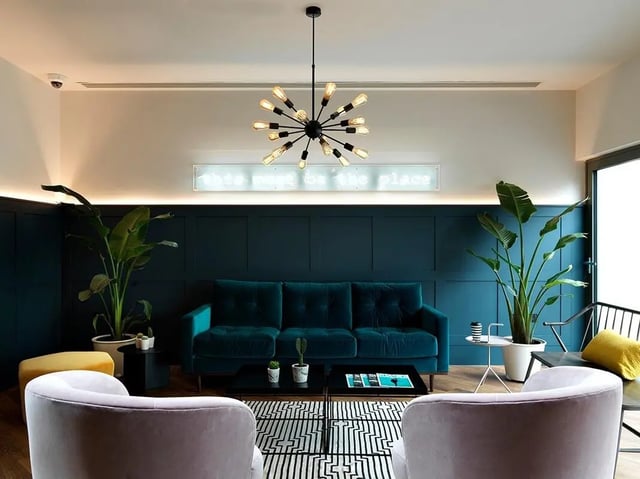 Teal sofa plants and chairs communal living room at Heald Court in Manchester Student Accommodation