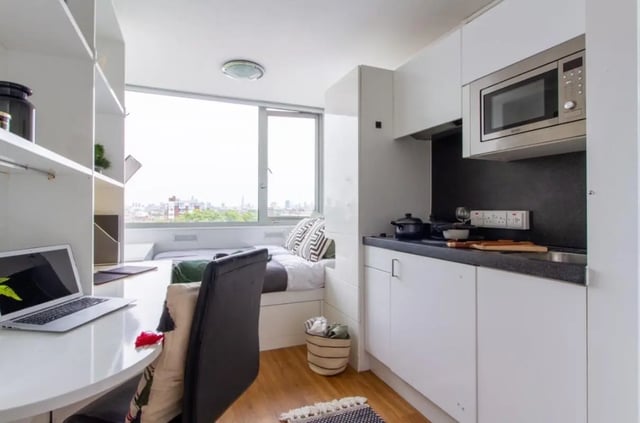 Bed desk kitchen unit microwave and bed. Living room at Chelsea Lightfoot Hall in London Student Accommodation