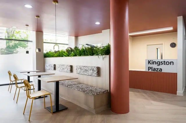 Tables chairs bench plants reception desk Common area at AXO Kingston in Kingston Upon Thames Student Accommodation