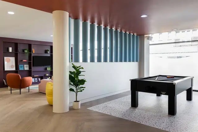 Pool table plants chair shelves television living area at AXO Kingston in Kingston Upon Thames Student Accommodation