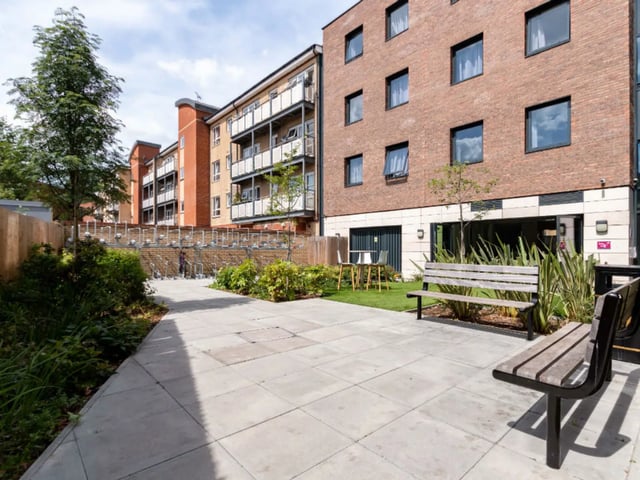 Wooden benches tables chairs bike racks exterior at AXO Kingston in Kingston Upon Thames Student Accommodation