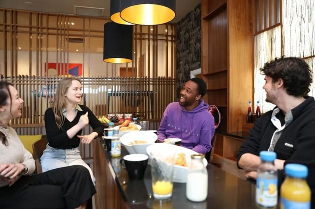 Students at a communal dining table living room at St. Andrew Street in Aberdeen Student Accommodation