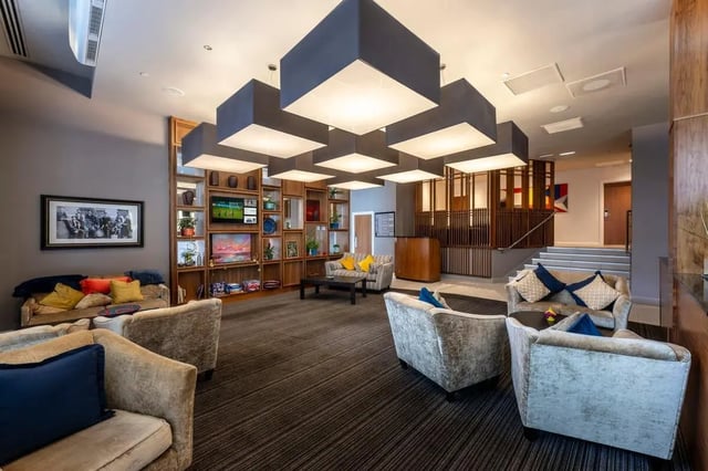 Sofas, shelves, tables, and chairs communal area at St. Andrew Street in Aberdeen Student Accommodation