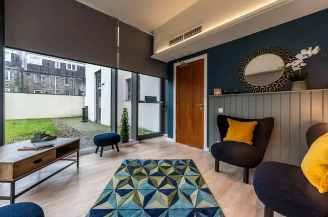 Blue chairs geometric rug coffee table living room at St. Andrew Street in Aberdeen Student Accommodation