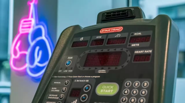 Treadmill console boxing gloves neon sign fitness room at Flora Building - Hoxton in London Student Accommodation