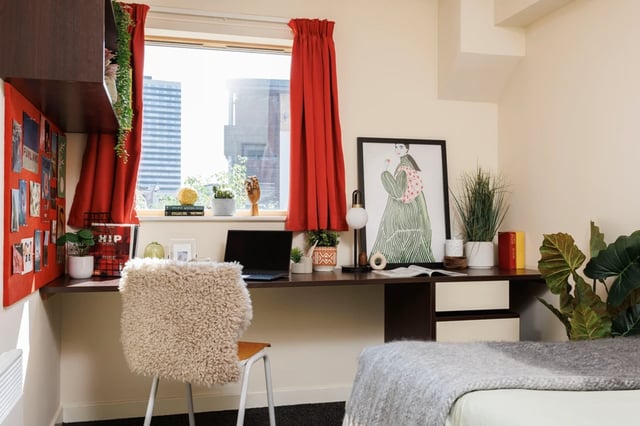Desk with laptop chair artwork and plant bedroom at Byron Central in Newcastle Upon Tyne Student Accommodation