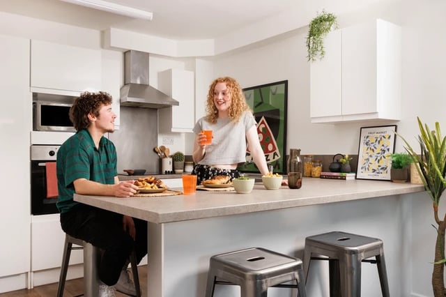 Couple eating at counter in modern kitchen at Byron Central in Newcastle Upon Tyne Student Accommodation