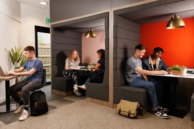 Students working in booths with laptops study area at Byron Central in Newcastle Upon Tyne Student Accommodation