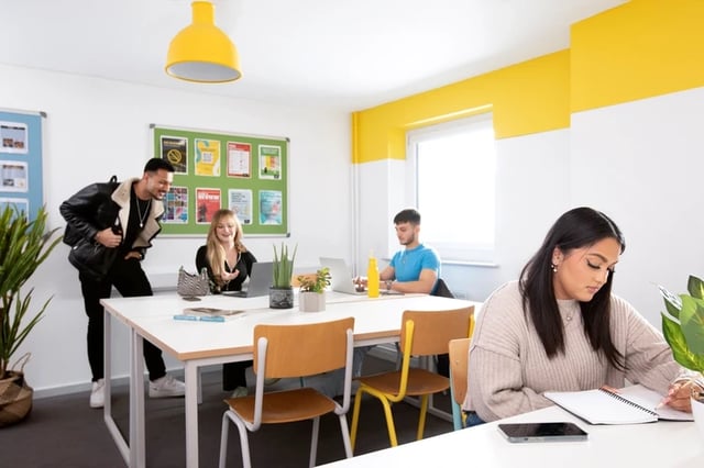 Students working at a large table study area at James Watt in Birmingham Student Accommodation