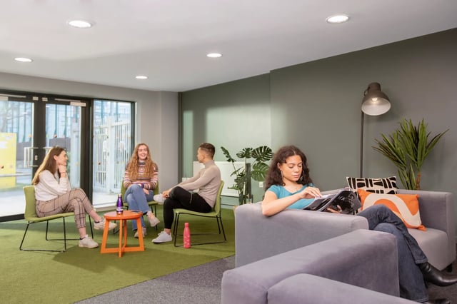 Students relaxing on chairs and sofa lounge area at James Watt in Birmingham Student Accommodation