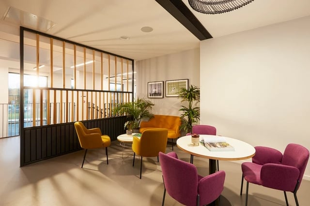 Orange sofa yellow chairs purple chairs oval table living room at Battery Park in Birmingham Student Accommodation