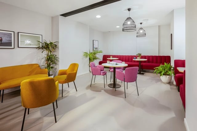 Yellow and pink seating with tables communal area at Battery Park in Birmingham Student Accommodation