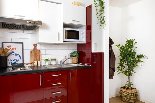 Red cabinets microwave white tiles poster kitchen at Romano Court in London Student Accommodation