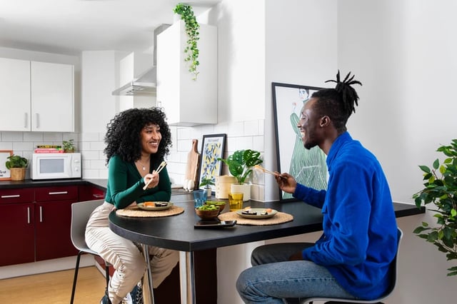 Couple eating sushi at kitchen dining table kitchen at Romano Court in London Student Accommodation