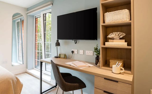 Desk with TV chair and shelves study area at Yugo Rothesay House in Bournemouth Student Accommodation